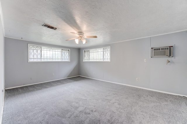 spare room featuring a textured ceiling, carpet floors, an AC wall unit, and ceiling fan