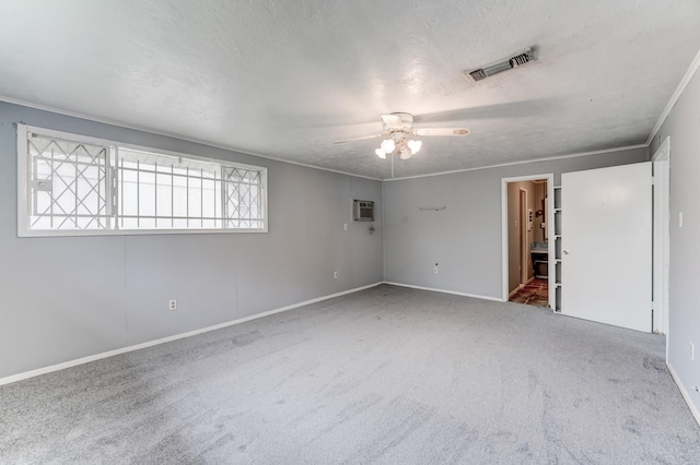 carpeted empty room with an AC wall unit, ceiling fan, and a textured ceiling