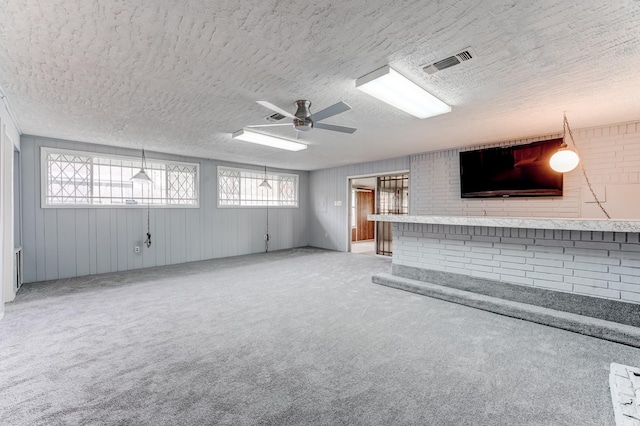 unfurnished living room featuring carpet, a healthy amount of sunlight, and a textured ceiling