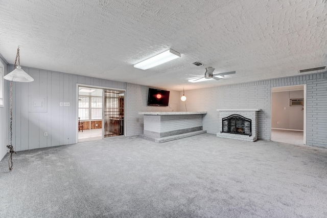 unfurnished living room with ceiling fan, a fireplace, and a textured ceiling