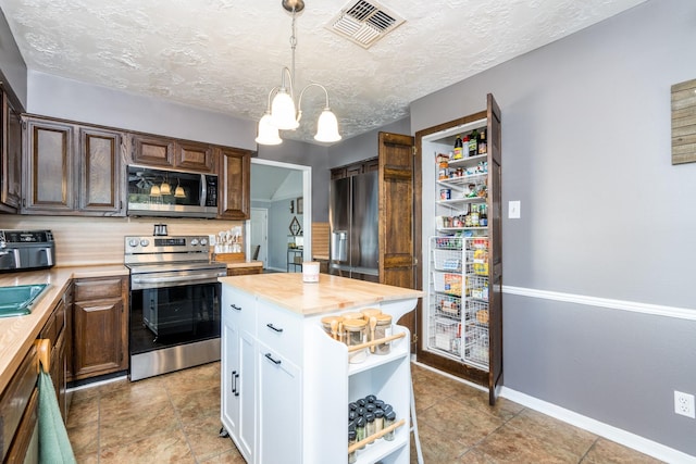 kitchen with dark brown cabinetry, white cabinetry, wooden counters, a center island, and stainless steel appliances