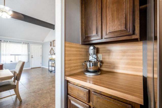 kitchen featuring vaulted ceiling with beams and backsplash