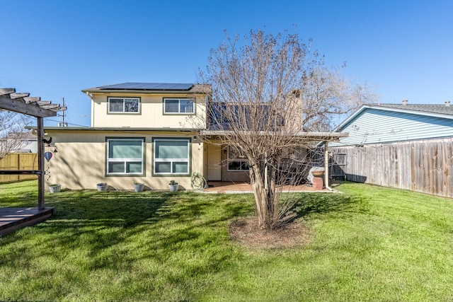 view of front of property featuring a pergola, a front yard, a patio, and solar panels