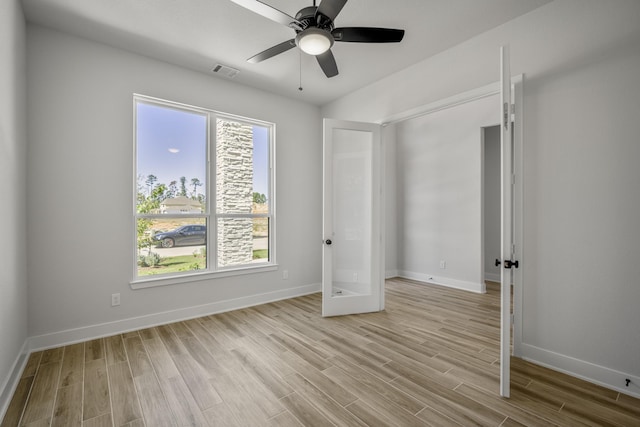 unfurnished bedroom with ceiling fan, light wood-type flooring, and multiple windows