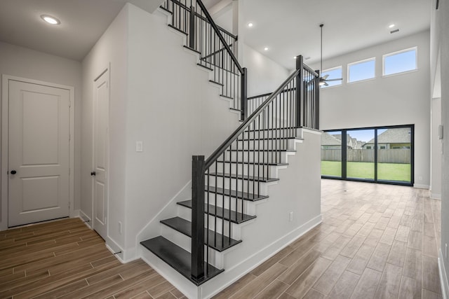 stairway with a high ceiling and ceiling fan