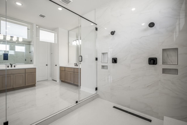 bathroom featuring a shower with door and vanity