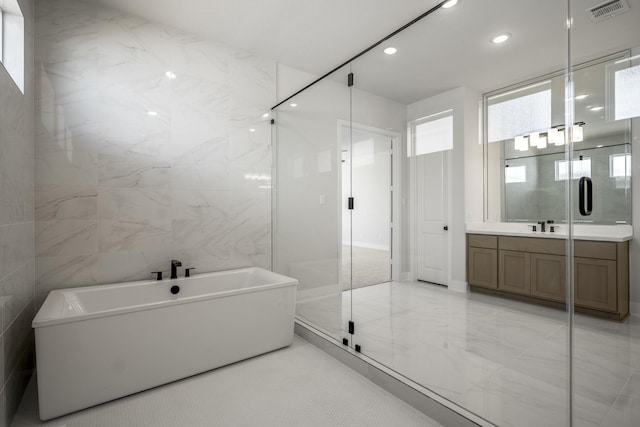 bathroom featuring vanity, separate shower and tub, and tile walls