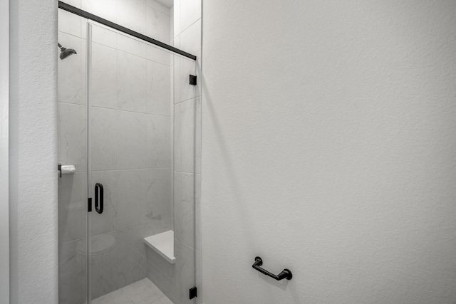 bathroom featuring a shower with shower door