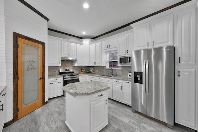 kitchen with white cabinets, stainless steel appliances, crown molding, and sink