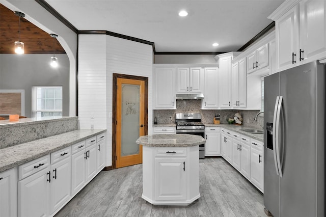 kitchen with light stone countertops, stainless steel appliances, white cabinets, and sink