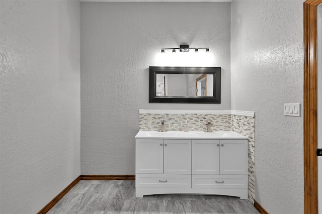 bathroom with backsplash, hardwood / wood-style floors, and vanity