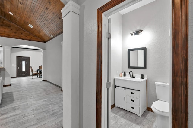 bathroom with ornate columns, wood ceiling, vanity, vaulted ceiling, and toilet