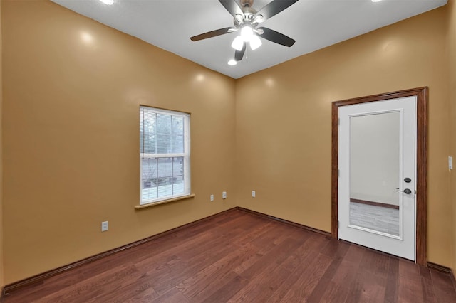 empty room with ceiling fan and dark wood-type flooring