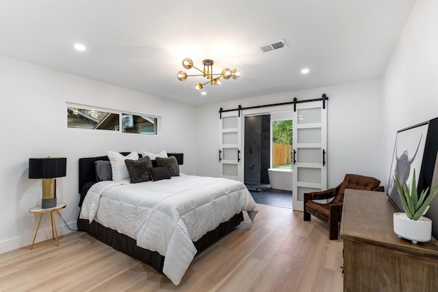 bedroom featuring a notable chandelier, a barn door, light hardwood / wood-style floors, and multiple windows