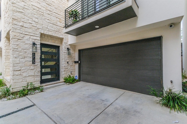 entrance to property with a garage and a balcony