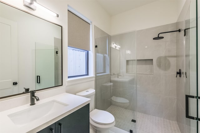 bathroom with a shower with door, vanity, and toilet