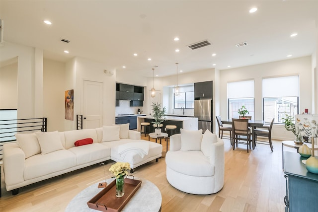 living room featuring light wood-type flooring and sink