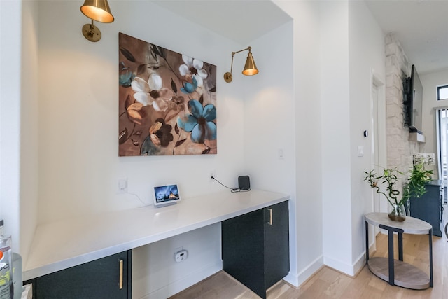 office featuring built in desk and light hardwood / wood-style floors