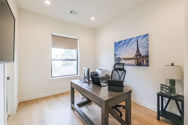 home office with light hardwood / wood-style floors