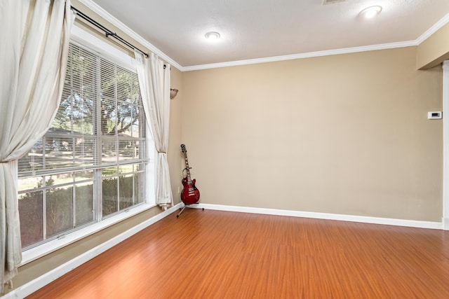 unfurnished room with ornamental molding, a healthy amount of sunlight, and wood-type flooring