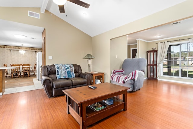 living room with hardwood / wood-style flooring, ceiling fan, and lofted ceiling with beams