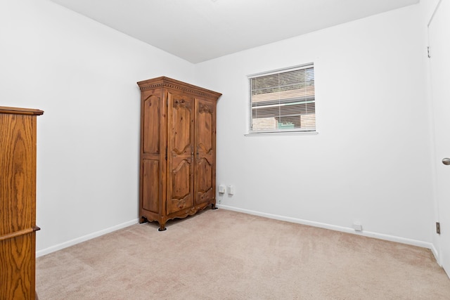 unfurnished bedroom featuring light carpet