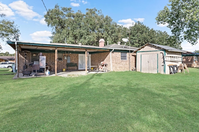 back of house with a lawn, a patio area, and a shed