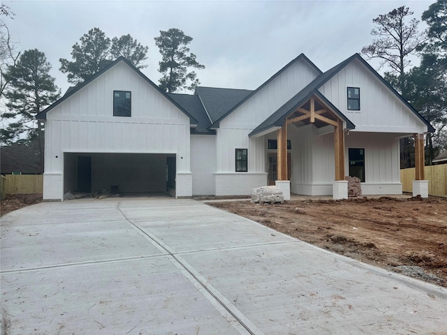 modern farmhouse featuring covered porch and a garage