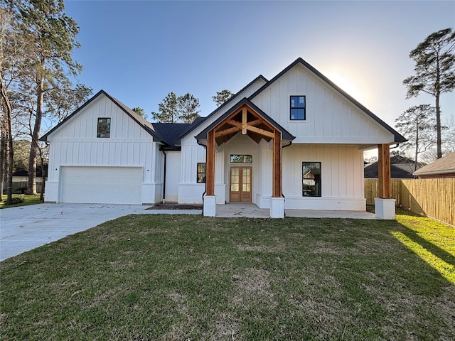 modern farmhouse style home with french doors, board and batten siding, concrete driveway, and fence