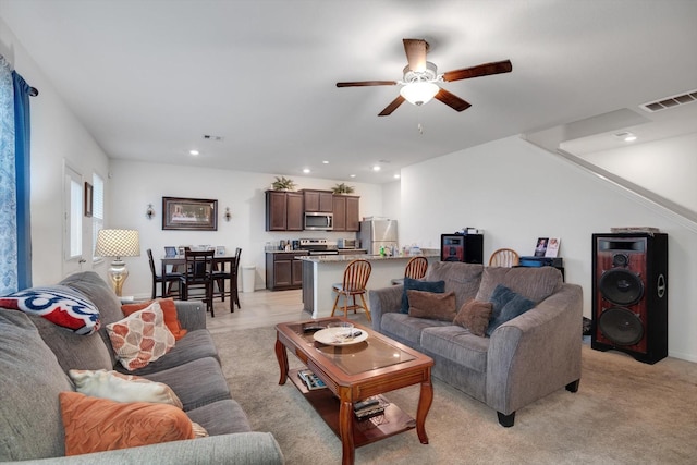 living room featuring light carpet and ceiling fan