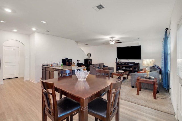 dining area featuring ceiling fan, light wood-type flooring, and sink