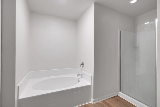 bathroom with wood-type flooring and independent shower and bath