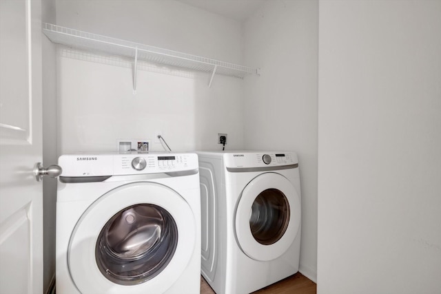 laundry area with hardwood / wood-style floors and washing machine and clothes dryer