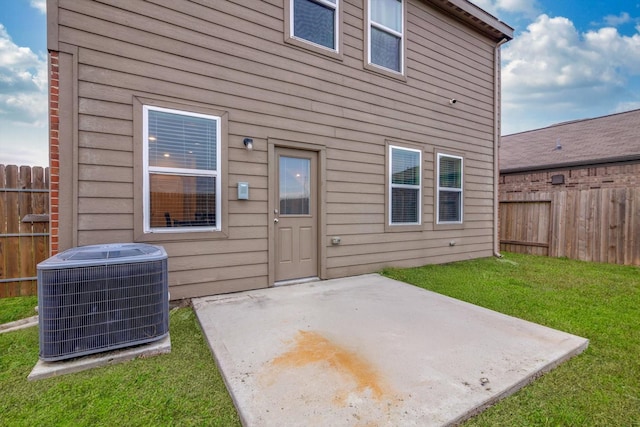 rear view of property with a lawn, a patio area, and central air condition unit