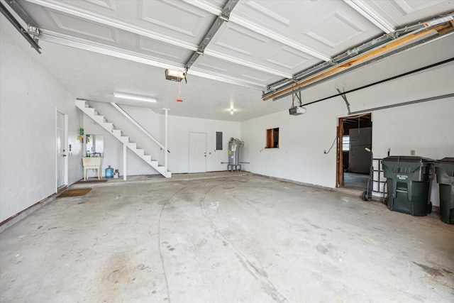 garage featuring sink, electric panel, and a garage door opener