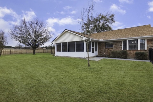 back of house featuring a yard and a sunroom