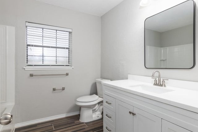 bathroom with toilet, vanity, and walk in shower