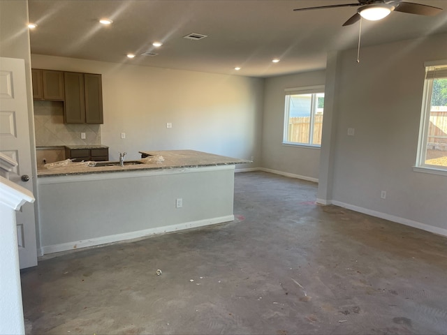 kitchen featuring a healthy amount of sunlight, light stone counters, and backsplash