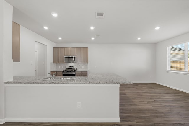 kitchen with light stone counters, sink, stainless steel appliances, and light brown cabinets