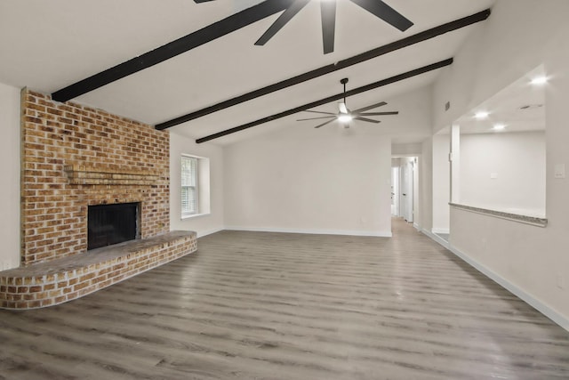 unfurnished living room featuring vaulted ceiling with beams, hardwood / wood-style flooring, a fireplace, and ceiling fan