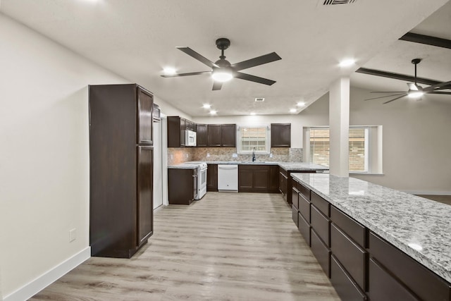 kitchen with sink, decorative backsplash, ceiling fan, light stone countertops, and white appliances