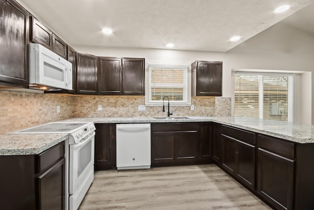 kitchen with sink, tasteful backsplash, kitchen peninsula, white appliances, and light hardwood / wood-style floors