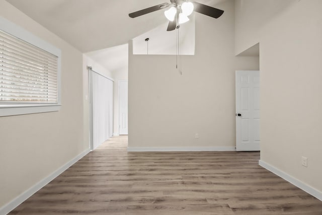 empty room featuring vaulted ceiling, hardwood / wood-style floors, and ceiling fan