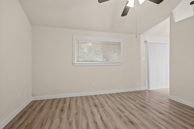 spare room with ceiling fan, vaulted ceiling, and light wood-type flooring