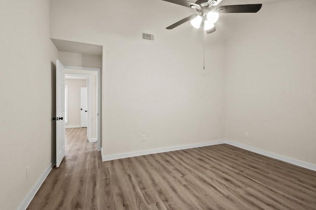 empty room with hardwood / wood-style floors and ceiling fan