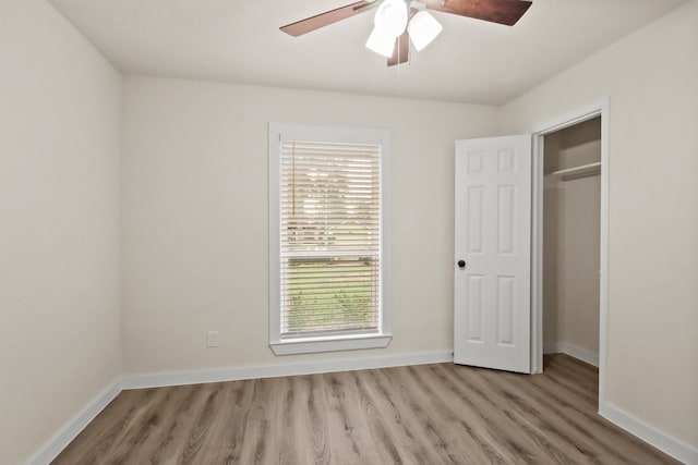 unfurnished bedroom featuring ceiling fan, a closet, and light hardwood / wood-style flooring