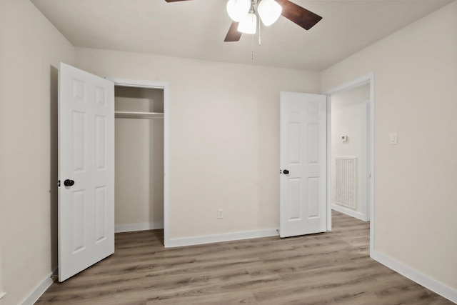 unfurnished bedroom with light hardwood / wood-style flooring, a closet, and ceiling fan