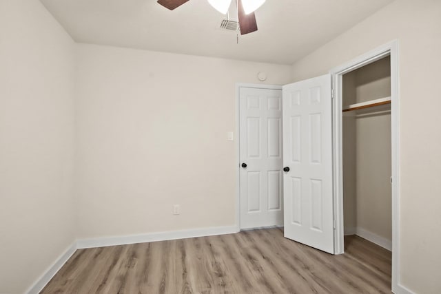 unfurnished bedroom featuring light hardwood / wood-style flooring, ceiling fan, and a closet