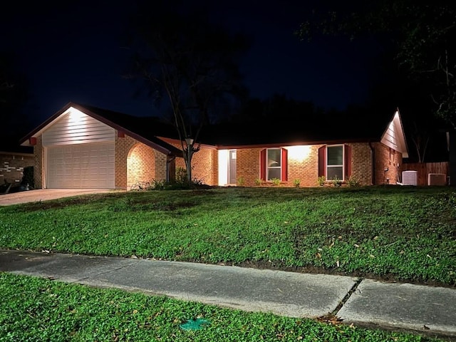 single story home with a garage and a lawn