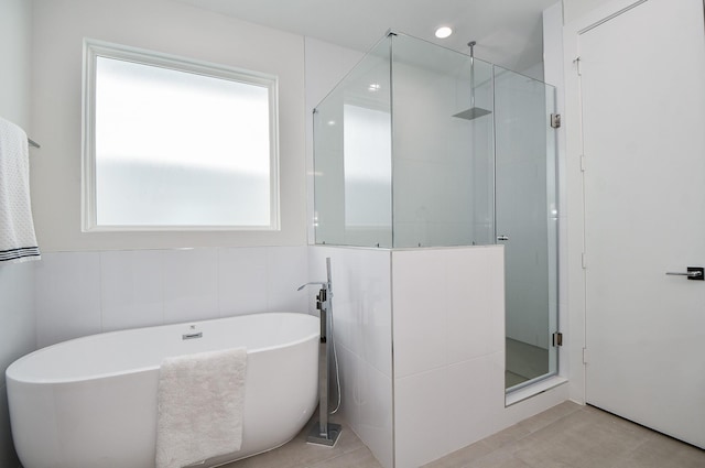 bathroom featuring tile patterned flooring, tile walls, and shower with separate bathtub